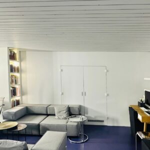 Home office with sofa landscape and desk, wide shot